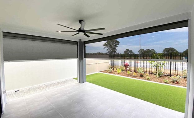 A Patio With A Zipscreen Awning And A Grassy Area — Premium Window Coverings In Chevallum, QLD