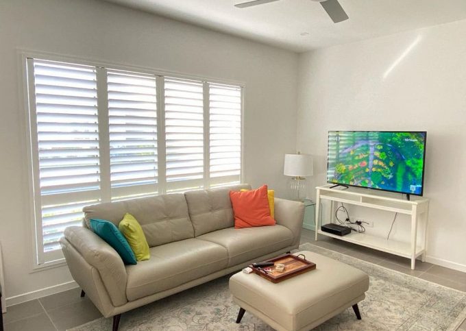 Beautiful Living Room with Plantation Shutters — Premium Window Coverings In Noosa, QLD